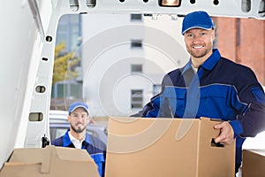 Mover Unloading Cardboard Box From Truck