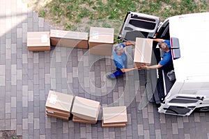 Movers carrying heavy boxes while moving