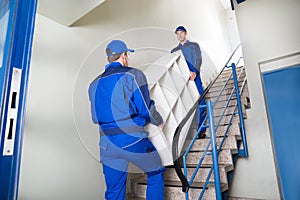 Movers Carrying Shelf While Climbing Steps At Home