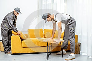 Movers placing furniture at home