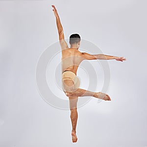 Moves made by the dance gods. Studio shot of a young man performing a ballet recital against a grey background.