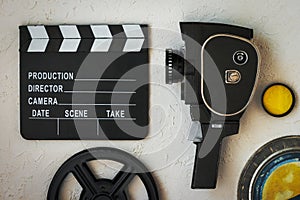 A movie camera, a clapperboard, a film box and a yellow filter
