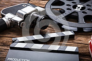 Movie Camera With Film Reel And Clapper Board On Wood