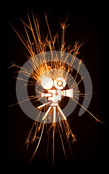 Movie camera icon in glowing sparks