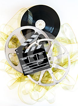 Movie clapper on 35mm yellow unrolled film and cinema reels