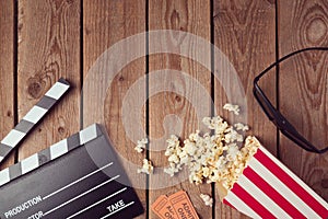 Movie clapper board, 3d glasses and popcorn on wooden background. Cinema concept