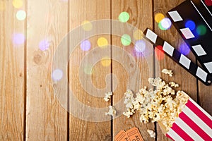 Movie clapper board and popcorn on wooden background. Cinema concept.