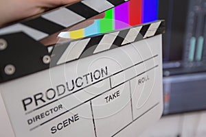 Movie clapper and editing room in background