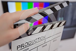 Movie clapper and editing room in background