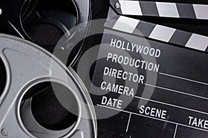 Movie clapper and film reel on a wooden background