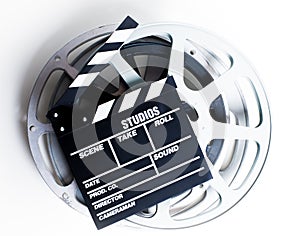 Movie clapper with film reels on white