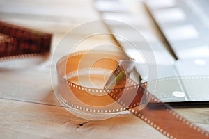 Movie clapper and film strip on wooden background