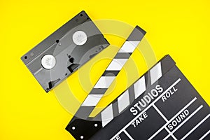 Movie clapper and Video cassette isolated on yellow background