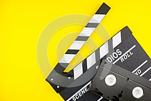 Movie clapper and Video cassette isolated on yellow background