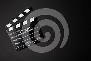 Movie clapperboard during the second wave of the coronavirus pandemic on a black background. Covid concept