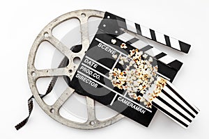 Movie film reel with clapperboard and popcorn. Cinema concept