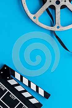 Movie premiere concept with clapperboard, film type on blue background top view space for text