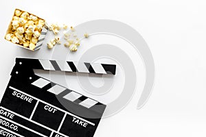 Movie premiere concept with clapperboard, popcorn on white background top view space for text