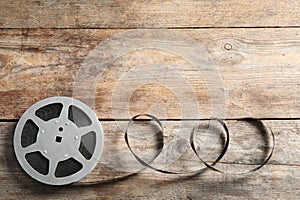 Movie reel on wooden background, top view with space for text.