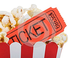 Movie ticket close up in a box of popcorn isolated on white