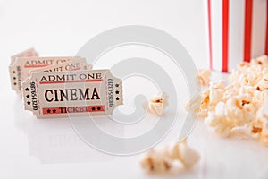Movie tickets and popcorn on white table front view closeup
