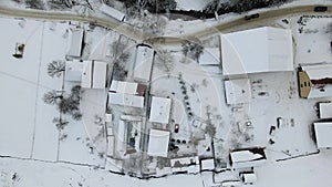 Moving 4K drone flight over the skiing resort village. Aerial winter landscape with small village houses between snow