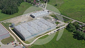 Moving Aerial Side Shot of Industrial Warehouse Loading Dock where Many Truck with Semi Trailers Load/ Unload Merchandise. Shot 4K