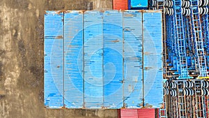 Moving belt at shipping container port, large blue metal containers stacked