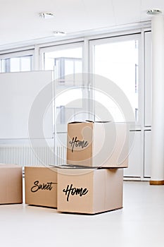 moving boxes in a empty room, home sweet home text in english