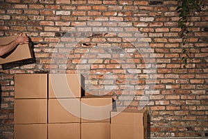 Moving boxes leans against a brick wall.