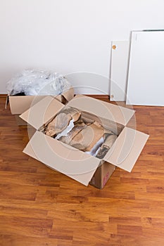 Moving boxes with packing material for fragile items on the floor