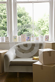 Moving Boxes By Sofa With Cards On Windowsill