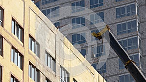 Moving of a building construction crane over the skyscrapper.