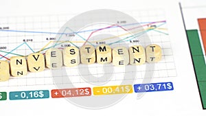 Moving the camera from the chart to the graphs and cubes with the inscription - Investment.