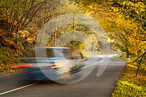 Moving car on the road in autumn nature