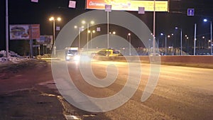 Moving cars, buses and advertising banners with illumination at night