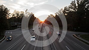 Moving cars on the motorway at sunset time. Highway traffic at sunset with cars. Busy traffic on the freeway, road top view