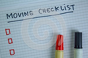 Moving Checklist write on a book. Supported by an additional services isolated on Wooden Table