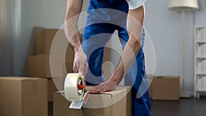 Moving company worker packing cardboard boxes, quality delivery services photo