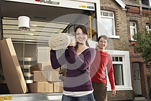 Moving Couple Carrying Rolled Carpet