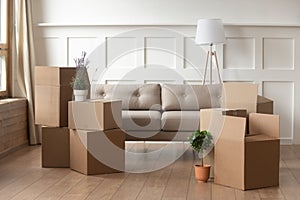 Moving day concept, cardboard boxes in modern house living room