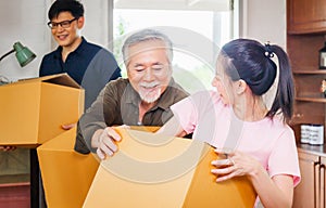 Moving day concepts, Asian family carrying boxes into new home, Happiness middle aged daughter son and senior father in new house