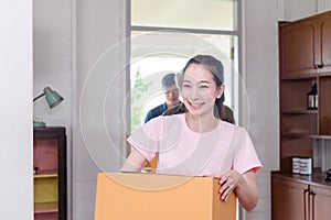 Moving day concepts, Asian family, Young daughter senior father and son carrying boxes into a new home