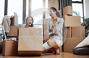 Moving day fun. Full length shot of an attractive young woman and her daughter moving into a new house.