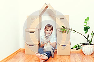 Moving day. Happy child and cat having fun together at moving day in new home