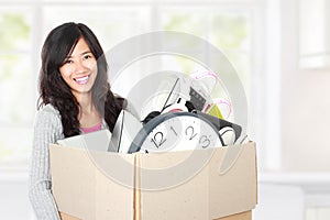 Moving day. woman with her stuff inside the cardboard box