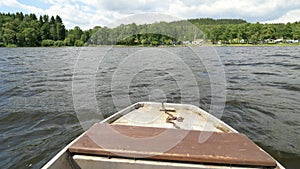 Moving front part of fishing vessel boat on big lake in wind