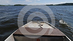 Moving front part of fishing vessel boat on lake in wind