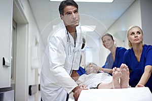 Moving her to the recovery theatre. A team of doctors pushing a patient down the hall.