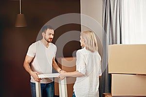 Moving House. Couple Carrying Furniture